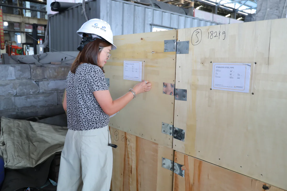 Hechuang team member reviewing an export crate